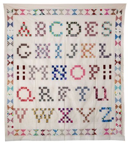 A scrappy pieced alphabet sampler quilt, with each letter made from small fabric squares